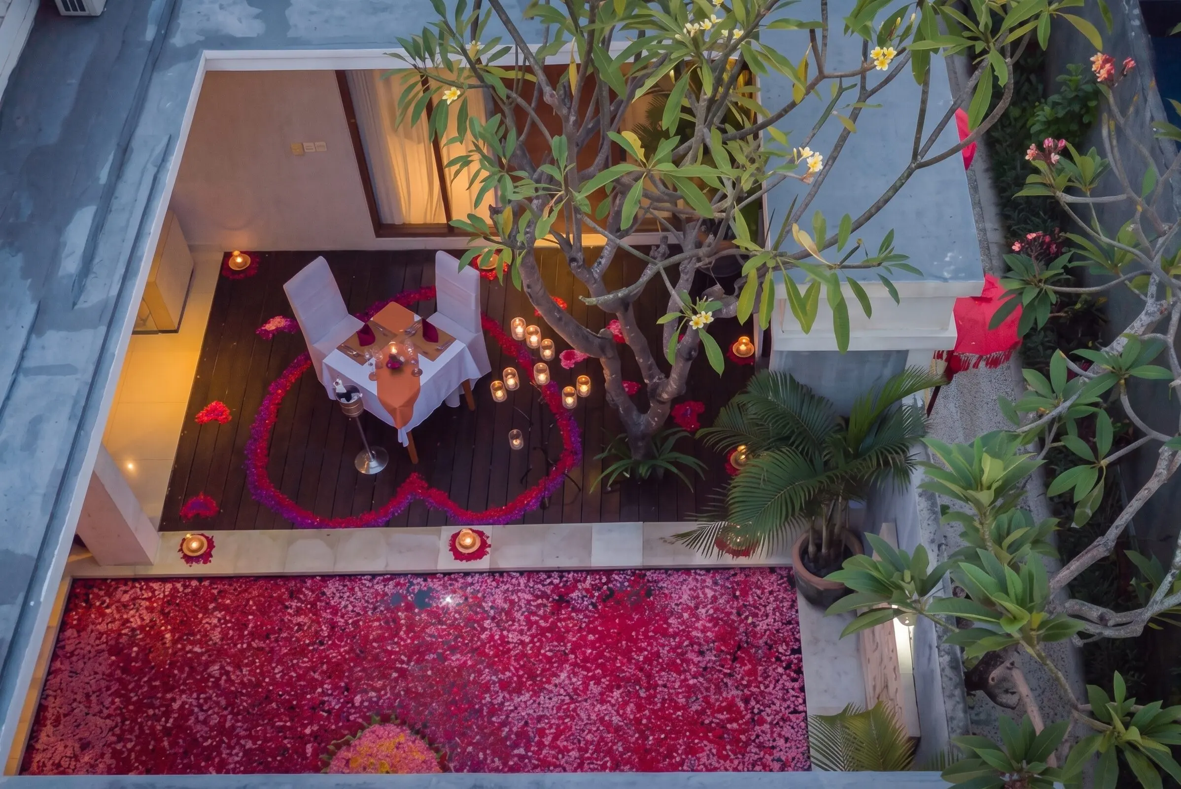 Romantic candlelight dinner setup with floral decorations by a private pool at The Light Exclusive Villas & Spa, Seminyak.
