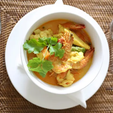 Creamy shrimp curry garnished with cilantro, served in a white bowl at The Light Exclusive Villas & Spa, Seminyak, Bali.