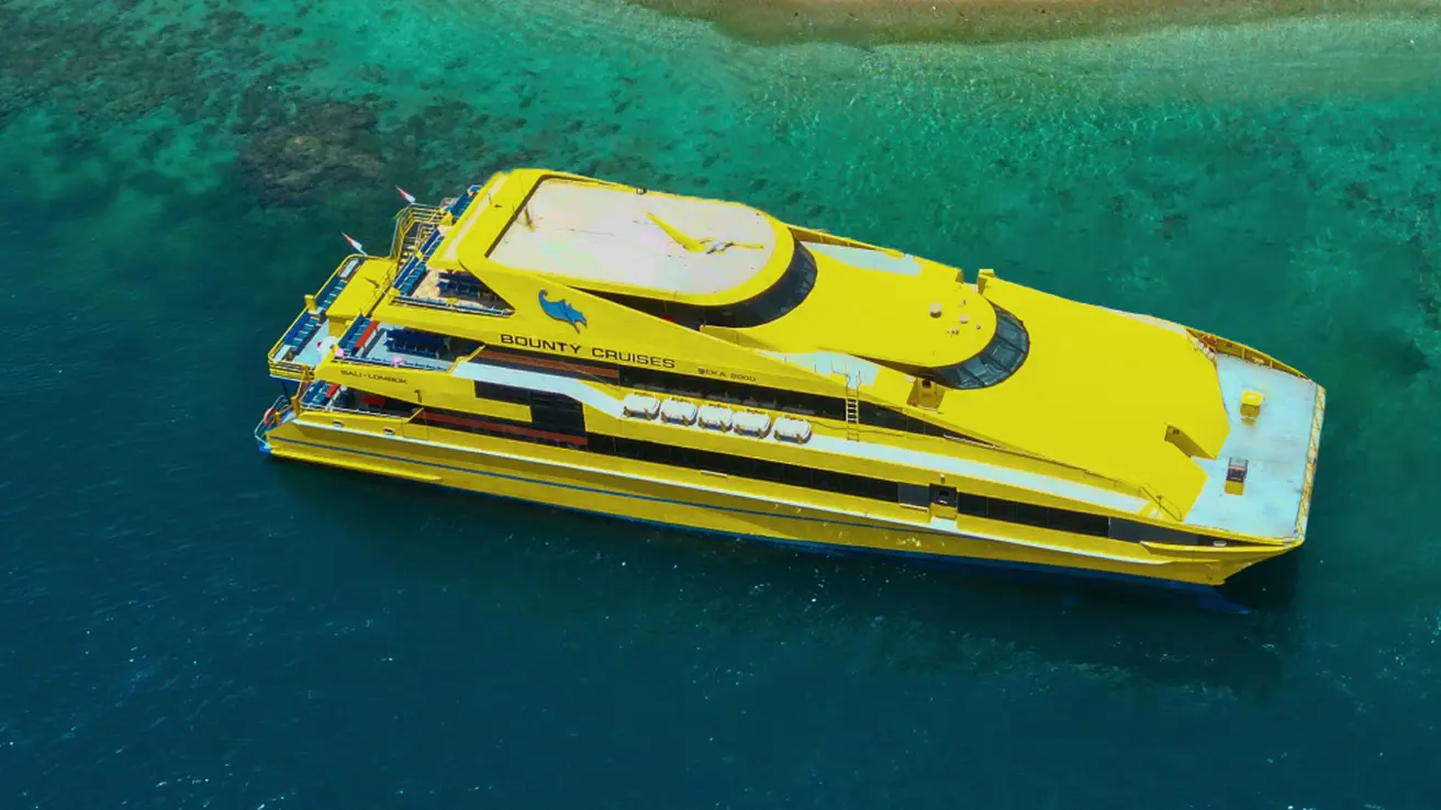 Yellow Bounty Cruises boat sailing on clear turquoise waters, near Seminyak, Bali.