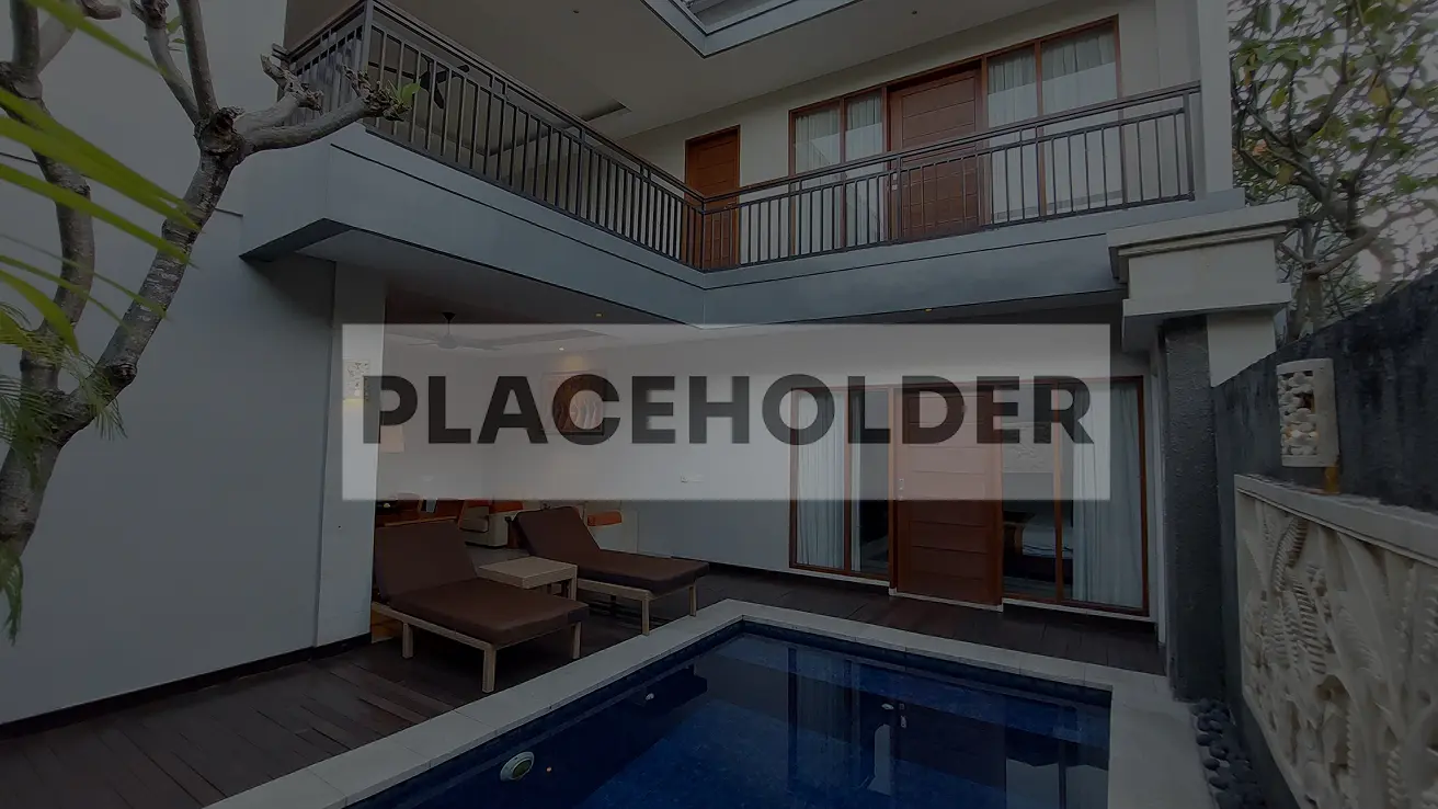 Private pool villa courtyard with deck chairs, surrounded by lush greenery and modern architecture at The Light Exclusive Villas, Seminyak.